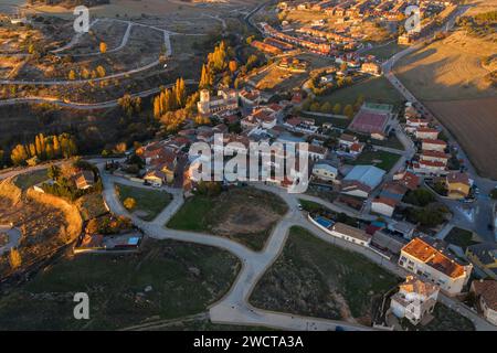 La lumière de l'heure dorée baigne une vue aérienne d'un village pittoresque dans la région d'Alcarria avec le paysage environnant Banque D'Images