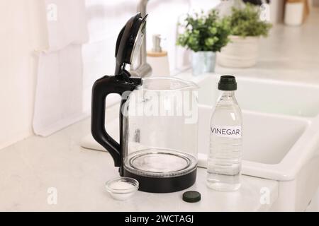 Nettoyage de la bouilloire électrique. Bouteille de vinaigre et bicarbonate de soude sur le comptoir dans la cuisine Banque D'Images