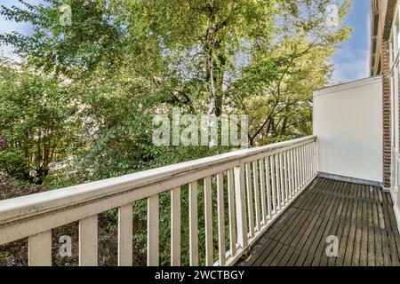 Un balcon serein donne sur un jardin animé avec une végétation luxuriante, présentant un espace extérieur relaxant. Banque D'Images