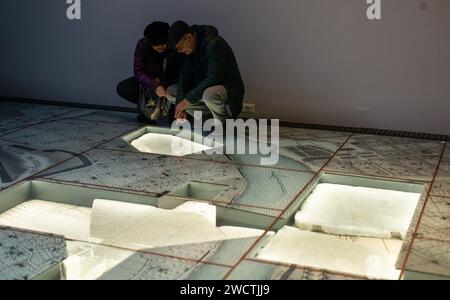 Rome, Italie. 16 janvier 2024. Les visiteurs font une visite au Musée de Forma Urbis à Rome, Italie, le 16 janvier 2024. Le Musée de la Forma Urbis, enfermé dans un nouveau parc archéologique, a récemment ouvert au public. Le musée abrite les fragments restants de la Forma Urbis Romae, la carte géante en marbre de la Rome antique gravée entre 203 et 211. Des artefacts épigraphiques et architecturaux sont présentés dans le parc archéologique, offrant un accès gratuit pour les citoyens et les touristes. Crédit : Li Jing/Xinhua/Alamy Live News Banque D'Images