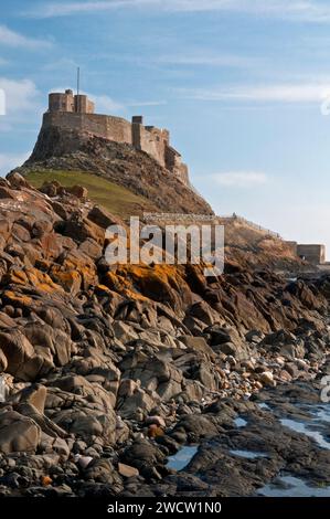 Portrait vue du château de Lindisfarne sur l'île de Lindisfarne vu de la plage voisine et du littoral en mars Banque D'Images