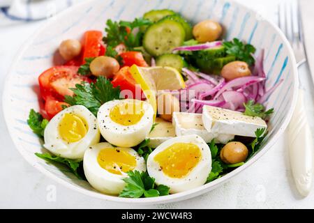 Petit déjeuner. Salade grecque et œufs durs. Salade de légumes frais avec tomates, concombres, olives, roquette et fromage. Banque D'Images