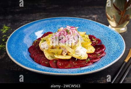 Salade épicée de hareng, betteraves, pommes de terre, cornichons et oignons rouges. Manger sainement. Banque D'Images
