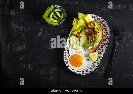 Petit déjeuner romantique pour la Saint-Valentin. Oeuf frit et toast avec avocat et fromage à la crème. Vue de dessus Banque D'Images