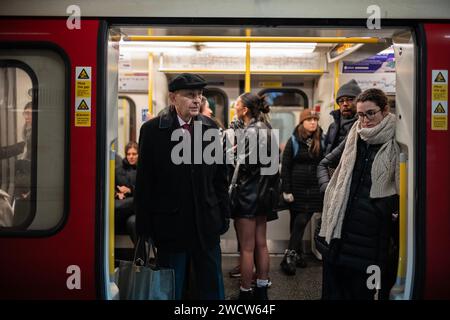 Les navetteurs de différentes générations se tiennent à l'intérieur d'un wagon du métro londonien alors qu'ils traversent le centre de Londres, en Angleterre, au Royaume-Uni Banque D'Images