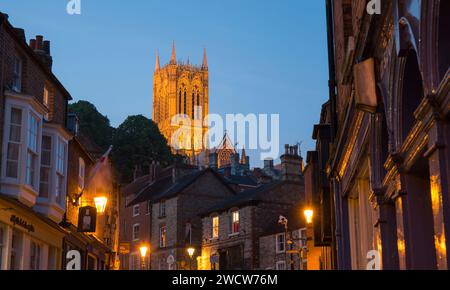 Lincoln, Lincolnshire, Angleterre. Admirez le détroit jusqu'à la tour centrale illuminée de la cathédrale Lincoln, au crépuscule. Banque D'Images