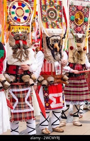 Des danseurs masqués kukeri avec une tenue complexe attendent de se produire au Surva International Mascarade and Mummers Festival à Pernik, Bulgarie, Europe Banque D'Images