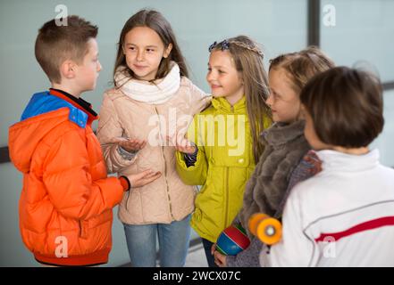 Les enfants communiquent dans la cour de l'école en automne Banque D'Images