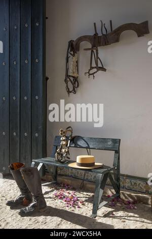 Espagne, Andalousie, Moron de la Frontera, Hacienda las Alcabalas, bottes, chapeau et matériel d'équitation dans le vestibule d'une Hacienda andalouse Banque D'Images