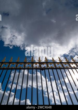 Vue depuis une clôture métallique avec des pointes dorées dans le ciel de Paris. Banque D'Images