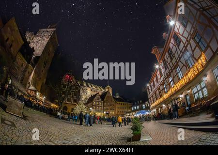 NUREMBERG, ALLEMAGNE - 16 DÉCEMBRE 2023 : vue nocturne avec des touristes se relaxant sur la place médiévale Tiergärtnertor, vieille ville. Banque D'Images