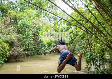 Cambodge, Kampong Phluk, les enfants plongent dans la rivière gonflée Banque D'Images