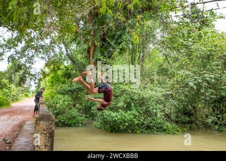 Cambodge, Kampong Phluk, les enfants plongent dans la rivière gonflée Banque D'Images