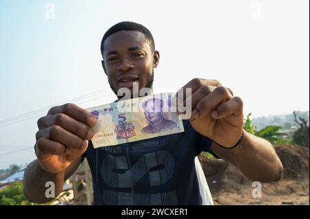 GHANA, Accra, bureau de change offre un billet chinois de cinq yuans avec l'image de Mao Zedong / GHANA, Accra, Geldwechsler bietet chinesische Banknote fünf Yuan mit Bild von Mao Tse Tung an Banque D'Images