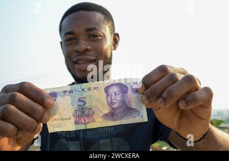 GHANA, Accra, bureau de change offre un billet chinois de cinq yuans avec l'image de Mao Zedong / GHANA, Accra, Geldwechsler bietet chinesische Banknote fünf Yuan mit Bild von Mao Tse Tung an Banque D'Images