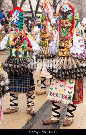 Danseurs masqués avec des masques colorés et des costumes de la région centrale de la Bulgarie au festival de mascarade et de Mummers de Kukeri Surva à Pernik, Bulgarie Banque D'Images