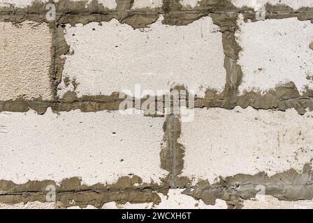 le mur est fait de blocs de mousse blancs avec des coutures de ciment rugueuses. Mur blanc de blocs Banque D'Images