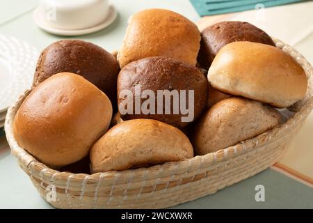 Panier avec une variation de petits pains de pain blanc et brun frais au four près sur la table Banque D'Images