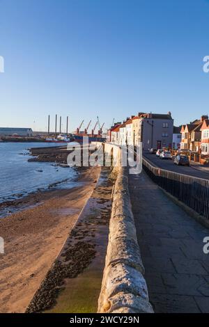 La plage, les murs de mer et les maisons géorgiennes avec les grues en arrière-plan à la Pointe, Old Hartlepool, Angleterre, Royaume-Uni Banque D'Images