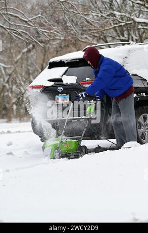 Streamwood, Illinois, États-Unis. Un homme travaille pour déneiger son allée après une tempête hivernale dans la banlieue de Chicago. Banque D'Images