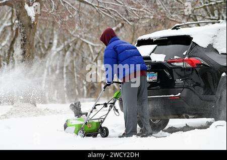 Streamwood, Illinois, États-Unis. Un homme travaille pour déneiger son allée après une tempête hivernale dans la banlieue de Chicago. Banque D'Images