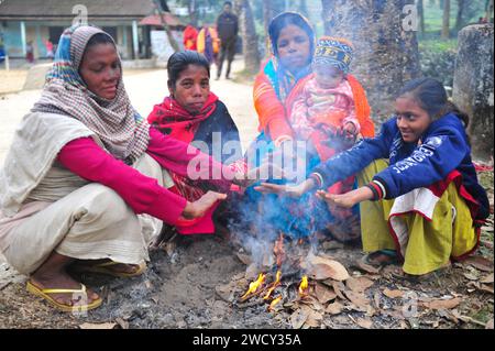 17 janvier 2024 Sylhet-Bangladesh : les enfants et les personnes âgées souffrent de la sévérité croissante de l'hiver. Surtout les résidents des jardins de thé à Sylhet car les hivers sont plus sévères dans les jardins de thé. Quelques femmes et enfants prennent la chaleur du feu en brûlant des feuilles mortes et tombées pour obtenir un peu de chaleur dans le jardin de thé Tarapur. Au cours des derniers jours, la température a chuté à travers le pays en raison d’une forte vague de froid. Le vent froid souffle aussi. En conséquence, la vie des gens a été perturbée en raison de l'augmentation de la sévérité de l'hiver. Le 17 janvier 2024 Sylhet, Banque D'Images