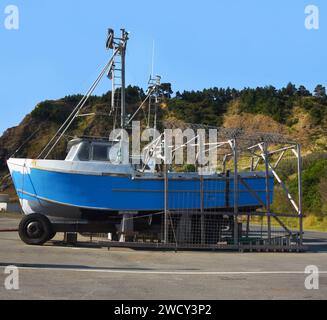 Le bateau bleu et patiné est mis en cale sèche dans l'un des deux seuls 'Dolly Docks' aux États-Unis, Port Orford, Oregon. Le bateau est encadré et monté sur des roues f Banque D'Images