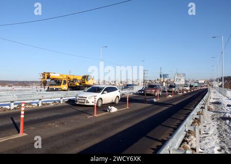 HOSTOMEL, UKRAINE - JANVIER 17, 2024 - des travaux de réparation sont en cours sur le pont de l'Hostome qui a été ruiné par l'armée ukrainienne qui a aidé à arrêter l'avance et à détruire une grande colonne de véhicules blindés russes essayant d'atteindre la capitale ukrainienne pendant la bataille de Kiev en février 2022, Hostomel, région de Kiev, nord de l'Ukraine. La circulation a été partiellement reprise le long du pont de 134 m de long sur la rivière Irpin à la périphérie d'Hostomel qui relie Bucha et Kiev. Banque D'Images