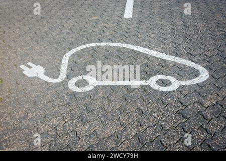 Panneau de recharge des véhicules électriques peints sur la route dans une station-service Banque D'Images