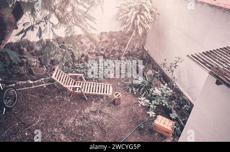 Vue aérienne d'une vieille chaise longue en bois dans une cour arrière, teinte appliquée. Banque D'Images