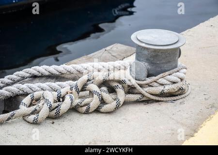 Poteau d'amarrage de quai métallique avec corde pour fixer des bateaux de pêche à proximité Banque D'Images