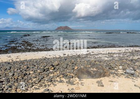 Vue de la côte volcanique rocheuse de Fuerteventura à Corralejo avec l'île de Lobos en arrière-plan Banque D'Images