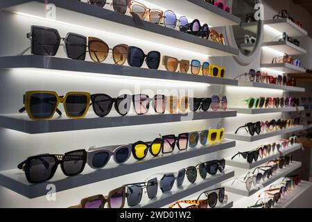 Étagères Storefront de diverses lunettes de soleil modernes dans le magasin de détail. Présentoir plein de lunettes de soleil. Tenez-vous debout avec des lunettes de soleil. Lunettes de soleil tendance à la mode Banque D'Images