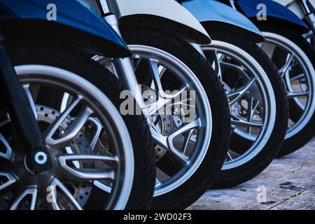 Gros plan d'une toute nouvelle roue de scooter alignée dans une rangée. Roue en caoutchouc de scooters avec disque de frein. Scooters électriques Banque D'Images