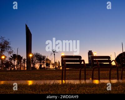 Vue à angle bas des chaises en bord de mer promenade la barceloneta pendant l'heure bleue. Barcelone, Espagne Banque D'Images