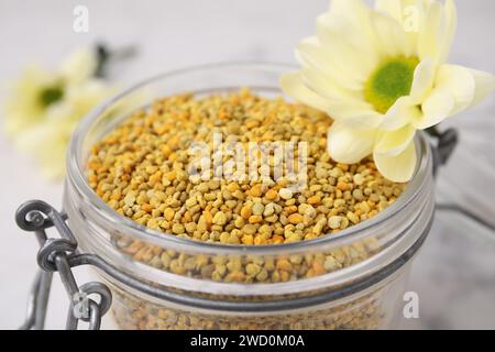 Granules de pollen d'abeille frais en pot et fleur, gros plan Banque D'Images