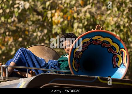 Bagan, Myanmar - 25 décembre 2019 : un enfant monte allongé sur le toit d'une camionnette, à côté d'énormes haut-parleurs peints Banque D'Images