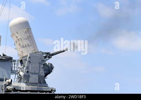 Un système d'armes rapprochées Mark 15 Phalanx tire des balles à bord du croiseur de missiles guidés USS Hue City. Banque D'Images