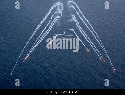 Un hélicoptère MH-60R Sea Hawk tire des fusées éclairantes de paille au cours d'un exercice d'entraînement Banque D'Images