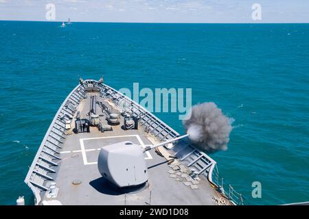 Le croiseur de missiles guidés USS Hue City tire son canon Mark 86 5 pouces dans la mer Noire. Banque D'Images