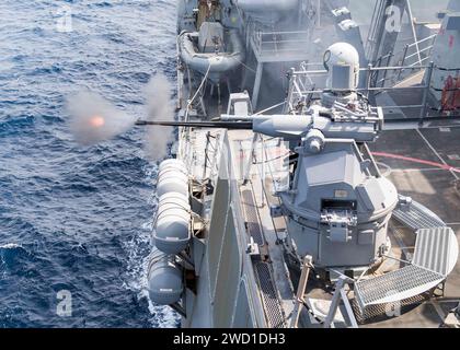 Le destroyer à missiles guidés USS Pinckney tire sa mitrailleuse Mark 38 25 mm. Banque D'Images