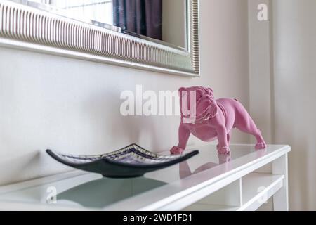 Une image en gros plan d'une statue de bouledogue anglais rose sur une étagère Banque D'Images