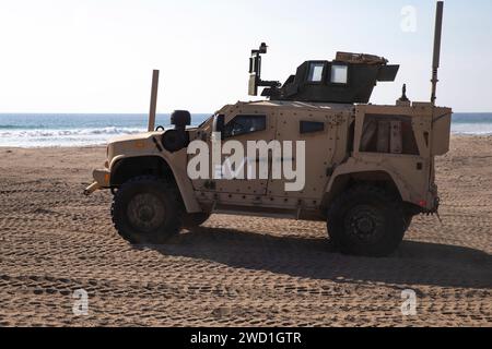 Les Marines américains manœuvrent un véhicule tactique léger conjoint à travers le sable. Banque D'Images