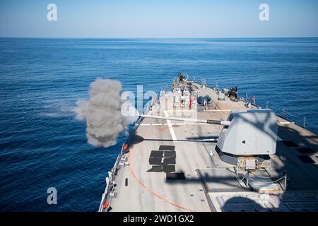 Le destroyer à missiles guidés USS Sterett (DDG 104) tire son canon Mark 45 5 pouces dans le golfe d'Oman. Banque D'Images