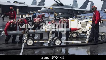 Les marins transportent des munitions sur le pont d'envol du porte-avions USS Carl Vinson. Banque D'Images