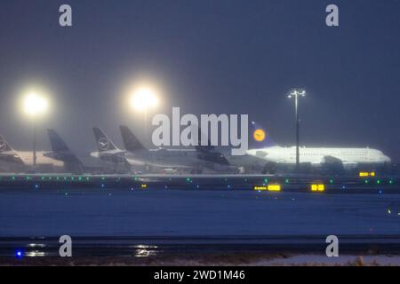 18 janvier 2024, Hesse, Francfort-sur-le-main : plusieurs avions Lufthansa sont stationnés à l'aéroport. De nombreux vols à l'aéroport de Francfort ont également été annulés pour jeudi en raison du risque continu de conditions glaciales. Photo : Lando Hass/dpa Banque D'Images