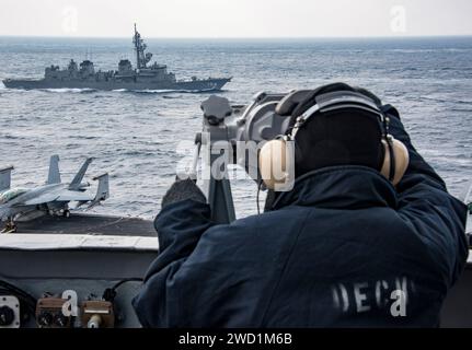 Le matelot se tient debout à l'arrière regarder devant le porte-avions USS Carl Vinson. Banque D'Images