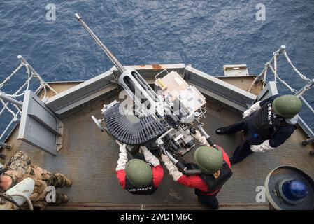 Gunner's Mate tire une mitrailleuse Mark 38 Mod-1 à bord de l'USS Bonhomme Richard. Banque D'Images