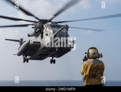 Aviation Boatswain's Mate signale qu'un CH-53E Super Stallion atterrit. Banque D'Images