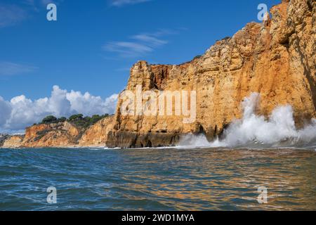 Vagues de l'océan Atlantique s'écrasant contre les falaises calcaires escarpées de la côte pittoresque de l'Algarve à Lagos, dans le sud du Portugal. Banque D'Images